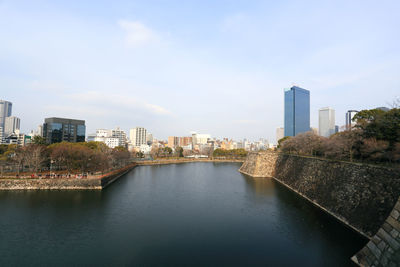 River amidst buildings in city against sky