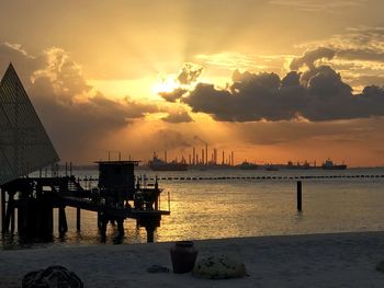 Pier over sea against sky during sunset