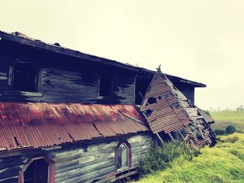 Abandoned house on field against clear sky