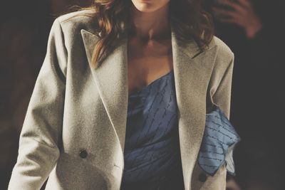 Midsection of woman standing against gray background