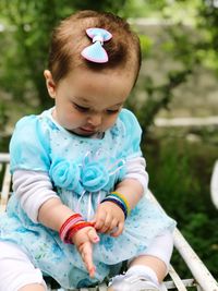 Cute baby girl sitting outdoors