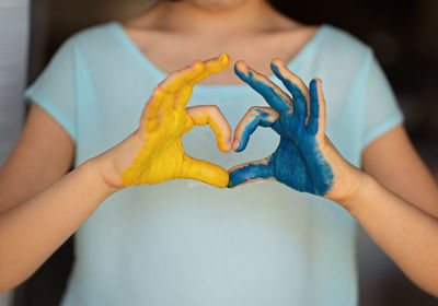 Child's hands painted on ukraine flag colors. peace for ukraine. stop war in ukraine.