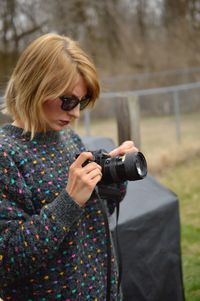 Young woman using dslr camera at park
