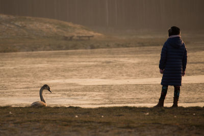 Rear view of man standing on shore