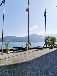 Full length of woman standing by lake against sky