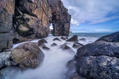 Scenic view of rocks in sea against sky