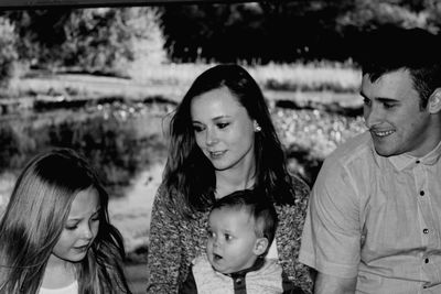 Smiling family looking at girl in public park