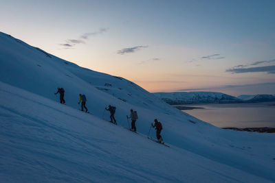 Group backcountry skiing in iceland during sunrise