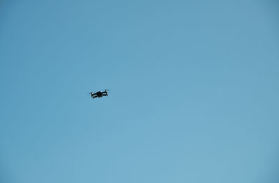 Low angle view of airplane against clear blue sky