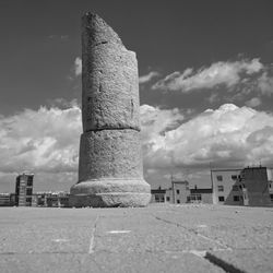 Surface level of old ruins in city against sky