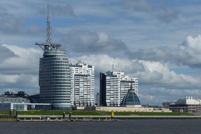 Buildings in city against cloudy sky