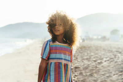 Portrait of young woman standing at beach