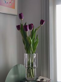 Close-up of purple roses in vase on table at home