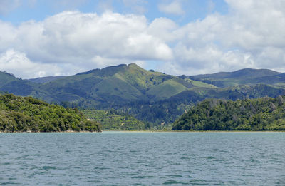 Scenic view of sea and mountains against sky