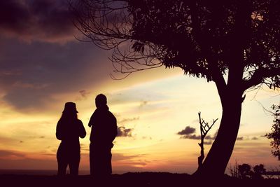 Silhouette men against sky during sunset