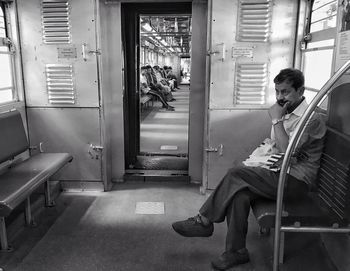 Man sitting on chair in corridor