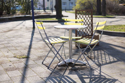 Yellow bistro chairs or garden chairs at a stainless steel bistro table or outdoor garden table
