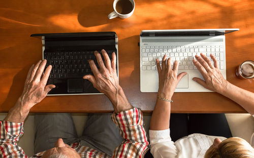 Low section of people sitting on table at home