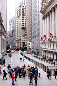 Group of people on street against buildings in city