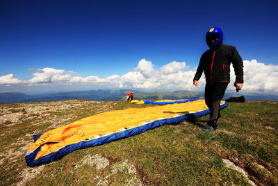 Full length of man by parachute on field against sky