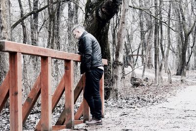 Man standing on tree trunk in forest