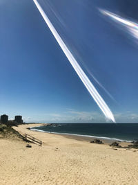 Scenic view of beach against blue sky