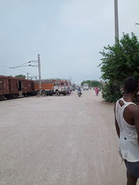 Rear view of man on street against sky