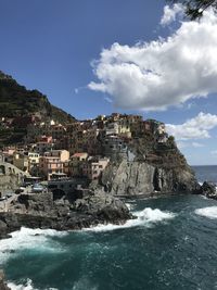 Scenic view of sea by city against sky