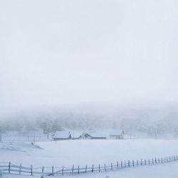 Snow covered landscape against clear sky