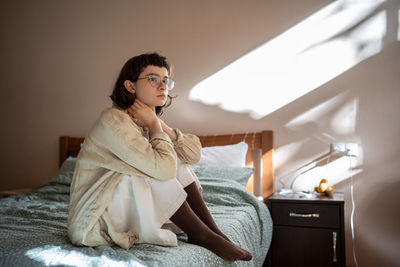 Portrait of young woman standing at home