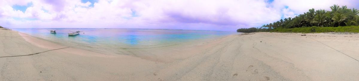 Scenic view of beach against cloudy sky