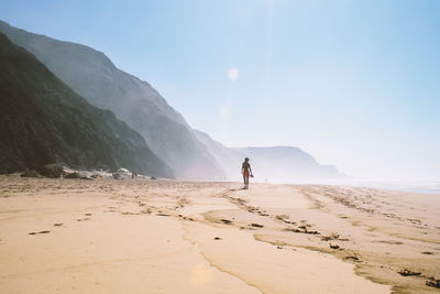 Woman at beach against sky