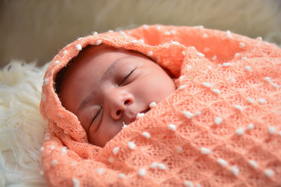 Close-up of cute baby sleeping on bed