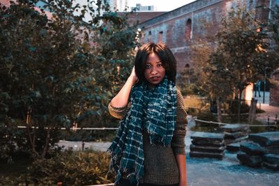 Portrait of teenage girl standing against trees