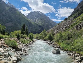 Scenic view of river amidst mountains against sky