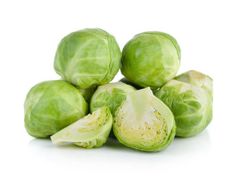 Close-up of green fruits against white background