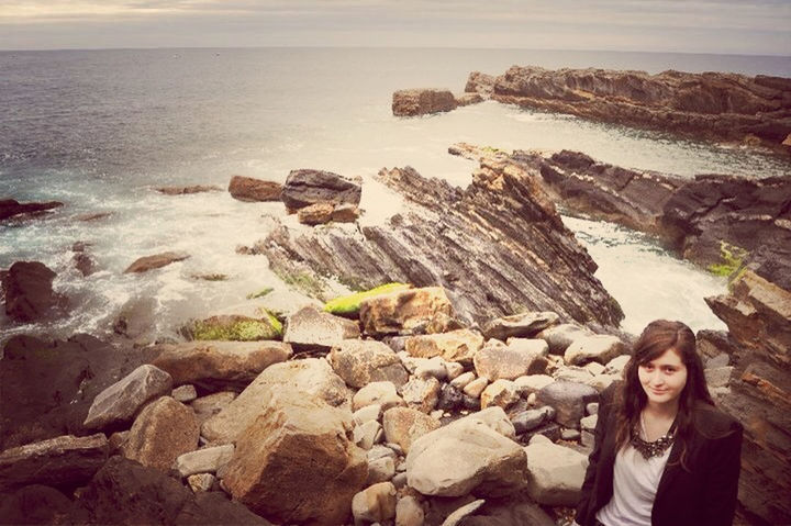 lifestyles, sea, water, leisure activity, beach, rock - object, shore, casual clothing, person, vacations, young adult, standing, horizon over water, nature, sky, outdoors, childhood, headshot