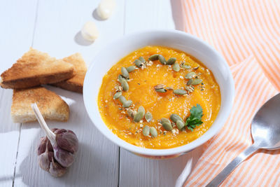 Pumpkin puree hot soup, spicy autumn vegan meal with pumpkin seeds, croutons and garlic