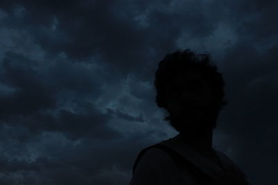 Low angle view of silhouette man against storm clouds