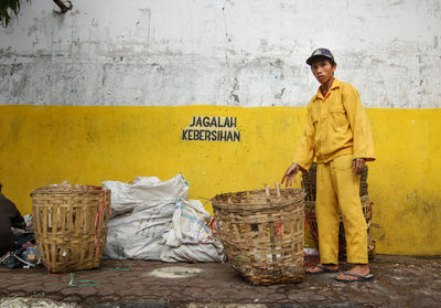 Portrait of man standing by garbage