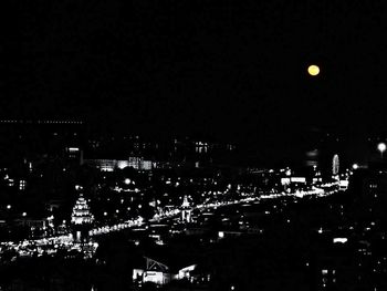 Illuminated cityscape against sky at night