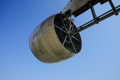 Low angle view of wheel against clear blue sky