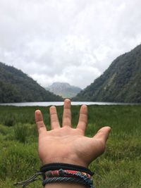 Midsection of person hand against mountain