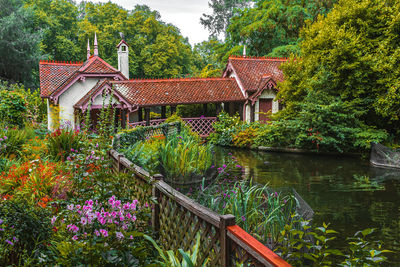 Wooden house by lake and trees by building