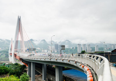 Bridge over cityscape against sky