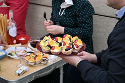 Midsection of people holding desserts on plates