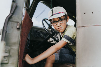 Portrait of angry boy sitting in car