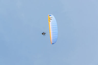 Low angle view of parachute flying against clear blue sky