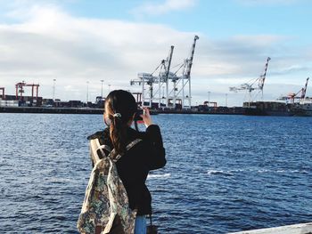 Rear view of woman on sea against sky