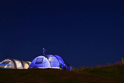 Tent against blue sky at night